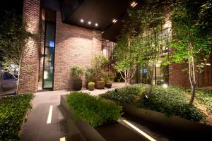 a building with a courtyard with trees and plants at MD HOTEL Dongtan - Formerly Staz Hotel Dongtan in Hwaseong
