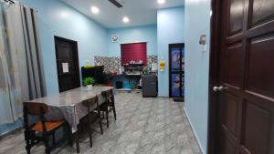 a dining room with a table and chairs at Rizki Homestay Nibong Tebal in Nibung Tebal