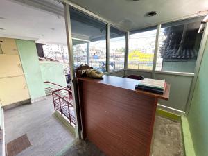 FortThe Kaya Backpackers Hostel的窗户间内带书桌的办公室