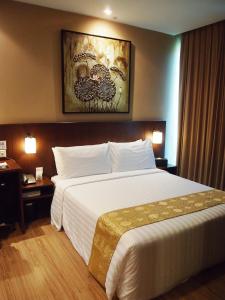 una habitación de hotel con una gran cama blanca. en Roomz Hotel, en Seria