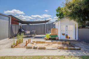 a backyard with a fire pit and a shed at Aurora Grove - A Familly Retreat at Caves Beach in Caves Beach