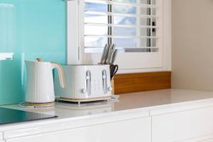 a kitchen counter with two appliances on a counter top at Aurora Grove - A Familly Retreat at Caves Beach in Caves Beach