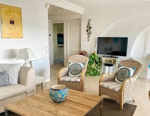a living room with a couch and a table at Appartement - villa Le Saint Georges avec superbe jardin et vue mer panoramique in Cannes