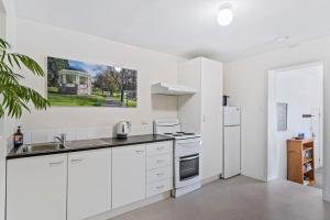 霍巴特Sir Tom inner city living with off street parking的厨房配有白色橱柜和白色冰箱