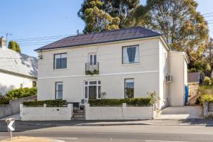 霍巴特Sir Tom inner city living with off street parking的街上的白色房屋,设有太阳能屋顶