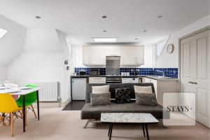 a living room with a couch and a kitchen at Cosy apartment in Moulsham, Long Stays Welcome in Chelmsford