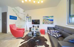 a living room with a gray couch and red chairs at Holiday house with a swimming pool Krk - 23580 in Krk