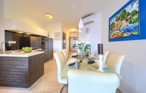 una cucina e una sala da pranzo con tavolo e sedie di Holiday house with a swimming pool Krk - 23581 a Krk