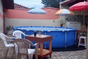 a table and chairs next to a large blue pool at Refúgio a 300m da prainha! in Rifaina