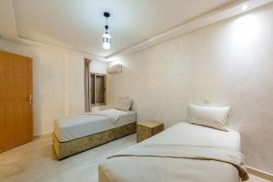 a hotel room with two beds and a window at Charming City Getaway in Marrakech