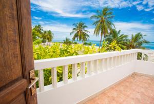 a room with a balcony with a view of the ocean at Faza View Inn, Maafushi in Maafushi