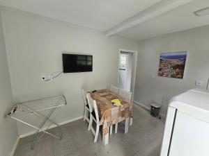Un comedor con una mesa y un televisor en la pared. en GH Canal da Barra, en Florianópolis