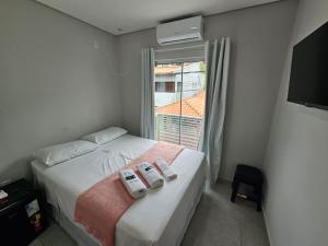 Un dormitorio con una cama con dos almohadas encima. en GH Canal da Barra, en Florianópolis