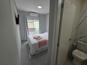 Un dormitorio pequeño con una cama y una ventana. en GH Canal da Barra, en Florianópolis 128 fotos más
