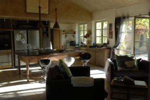 a kitchen with couches and a table in a room at Clos De La Fontaine in Cabrières-dʼAvignon