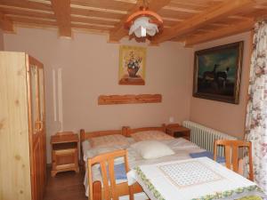 a bedroom with a bed and a table with chairs at Privát U Slávky in Ždiar