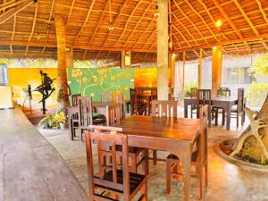 a dining room with tables and chairs and a painting at Werala Beach Resort in Kalpitiya