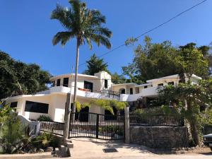 a white house with a palm tree in front of it at Casa Kahakai 2 in Chacala