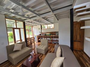 a living room with a couch and chairs at CABAÑAS GOLDEN TANAGER in Mindo