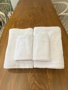 two white towels sitting on top of a wooden table at 大溪漁港蜜月灣Luna民宿2號館 in Toucheng