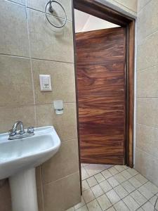a bathroom with a sink and a wooden door at Apartment 3 Maleconcito del Sol Barra de Navidad in Barra de Navidad +42 photos