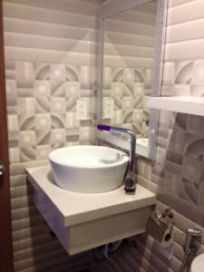 a white sink in a bathroom with a mirror at Nha Trang Seaview Penthouse Apartment in Nha Trang