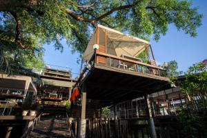 
a large wooden structure with a clock on top of it at Bangkok Tree House in Bangkok
