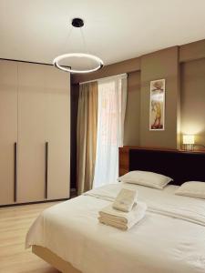 a bedroom with a large bed with towels on it at Smart Rent Apartment in Tirana