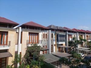 a row of apartment buildings with tables and trees at Casa Como Ciumbuleuit - spacious 3 Beds Townhouse in Bandung