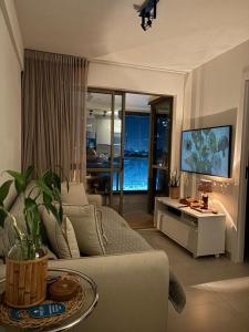 サルバドールにあるBeach Class - Barra Ondina SSAのソファとテレビのあるリビングルーム