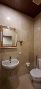 a bathroom with a sink and a toilet and a mirror at Gustav Bali Homestay and Massage in Sanur +16 photos
