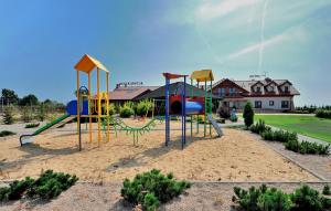 a playground with a slide in the sand at Hotel Dwór Choiny in Kazimierzówka
