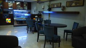 a restaurant with tables and chairs and a large video game at Hmaasat Intour Hotel فندق همسات انتور in Jazan