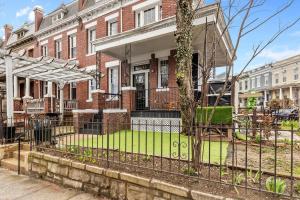 a brick house with a fence in front of it at Garden-Level 2-BR Apt in Historic Petworth Home in Washington, D.C.