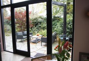 Una puerta abierta a un patio con mesa y sillas. en De Bosuil, en Bergen