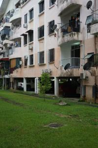 an apartment building with a grassy yard in front of it at Domus in Kota Kinabalu