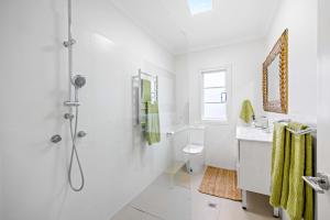 une salle de bain blanche avec douche et toilettes dans l'établissement Tribal Tides - waterfront cottage, pet friendly, à Dunbogan 17 autres photos