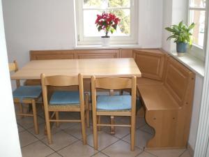 a wooden table and chairs in a kitchen with a window at San Cristoforo in Canazei