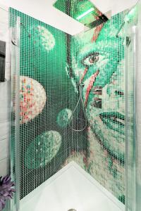 a bathroom with a glass shower with a woman at La Madegra Seasuite in Salerno