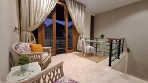 a living room with a chair and a window at Casa Como Ciumbuleuit - spacious 3 Beds Townhouse in Bandung