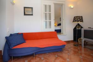 a blue and orange couch in a room with a television at Apartment Klepac in Punat
