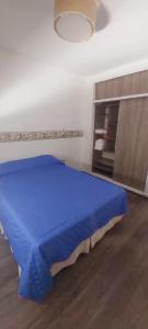 una camera da letto con un letto blu in una stanza di Hermoso depto céntrico! a Corrientes