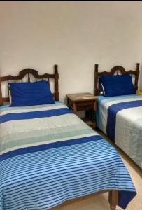 two beds in a room with blue and white sheets at Apartment 4 Maleconcito del Sol Barra de Navidad in Barra de Navidad +43 photos