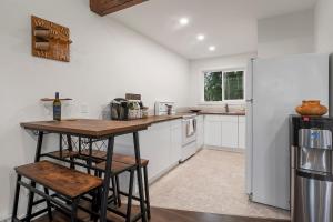 a kitchen with a table and a refrigerator at Brickwood Cabin in Sayward