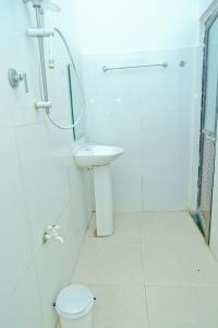 a bathroom with a shower and a toilet and a sink at Ninety Nine Grand Hotel in Badulla +92 photos