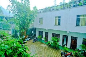 a building with motorcycles parked in front of it at Ninety Nine Grand Hotel in Badulla