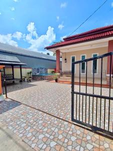a fence in front of a house with a patio at Cassa Villa Guest House Pasir Mas in Pasir Mas