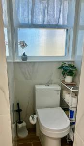 a bathroom with a white toilet and a window at 3 doors down to New Orleans , Excellent location! in Arabi +20 photos