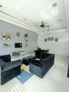 a living room with a couch and a tv at Cassa Villa Guest House Pasir Mas in Pasir Mas