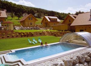 two women sitting in a swimming pool in a backyard at ÖKO Feriendorf Schlierbach in Schlierbach